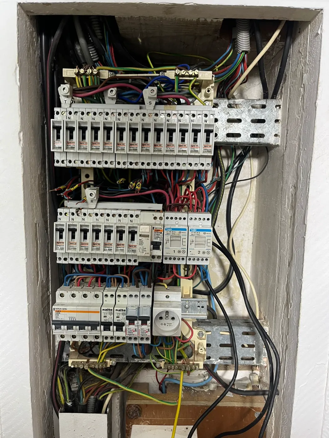 Tableau électrique vétuste au câblage anarchique avant remise aux normes.